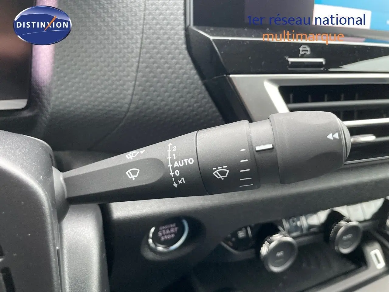 Gros plan sur la commande des essuie-glaces à l'intérieur d'une Citroën C4 blanche métal 2024, avec tableau de bord noir.