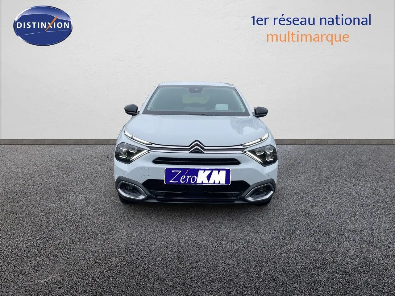 Vue frontale d'une Citroën C4 blanche métal 2024 avec feux LED et calandre distinctive, sur fond neutre.