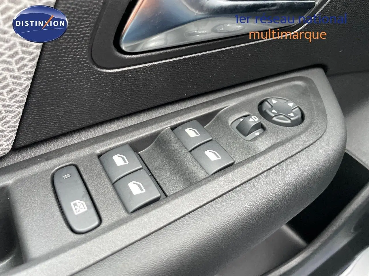 Gros plan sur les commandes de lève-vitres et rétroviseurs côté conducteur d'une Citroën C4 blanche métal 2024.