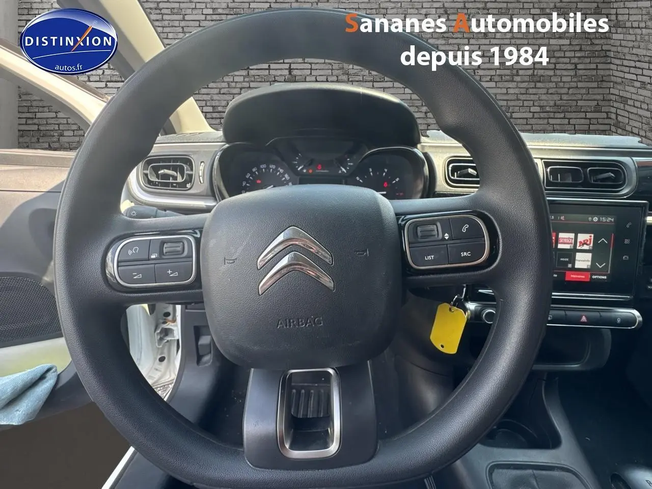 Volant Citroën C3 2023 en vue frontale, avec commandes audio intégrées et tableau de bord numérique visible.