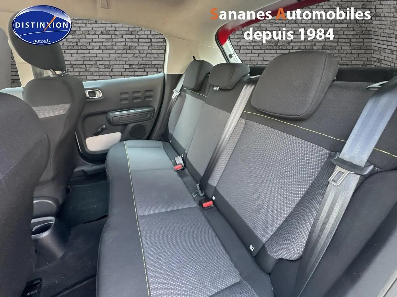 Vue intérieure sur la banquette arrière grise avec surpiqûres jaunes de la Citroën C3 2023 toit rouge et caisse blanche.