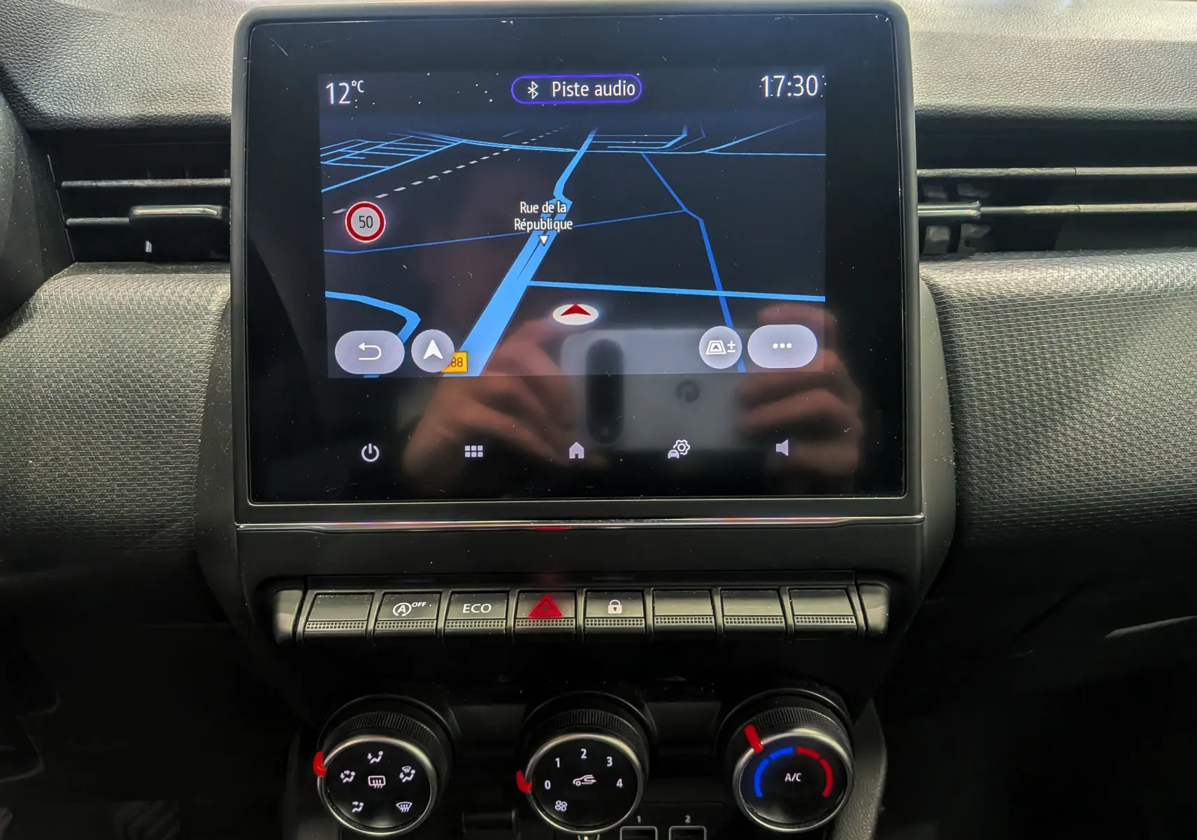 Vue rapprochée de l’écran tactile central avec navigation active sur Renault Clio V Business 2020, tableau de bord noir.