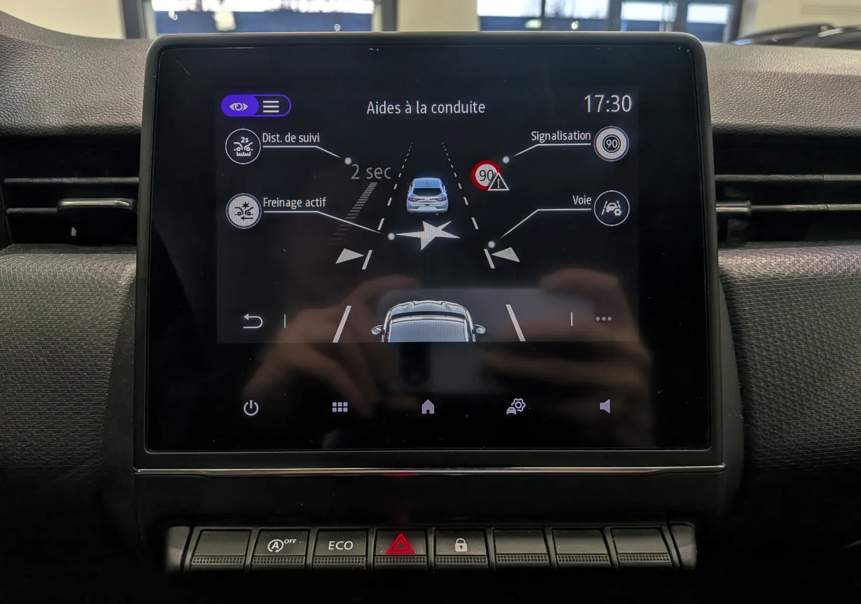 Écran central de la Renault Clio V Business 2020 montrant les aides à la conduite avec interface noire et icônes blanches.