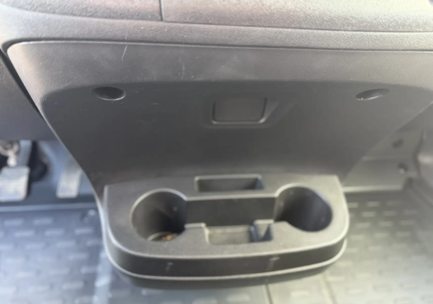 Gros plan sur le porte-gobelets noir situé sous le tableau de bord de l’Opel Movano Fourgon blanc, côté conducteur.