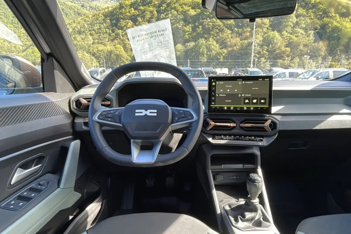 Vue intérieure avant du Dacia Bigster gris schiste 2025, volant multifonction, écran tactile 10 pouces et boîte manuelle.