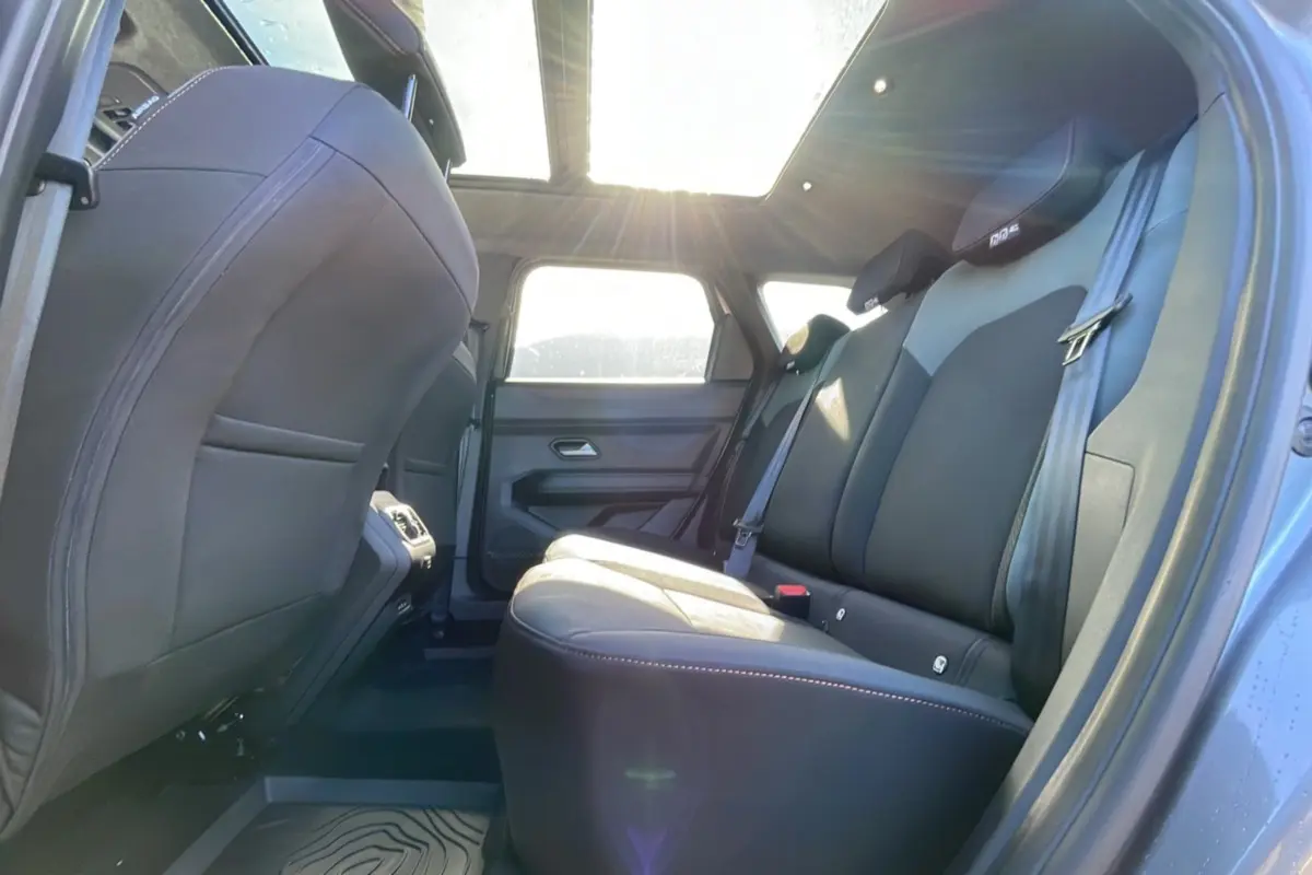 Vue intérieure arrière côté droit du Dacia Bigster gris schiste, avec banquette en cuir et toit ouvrant panoramique lumineux.
