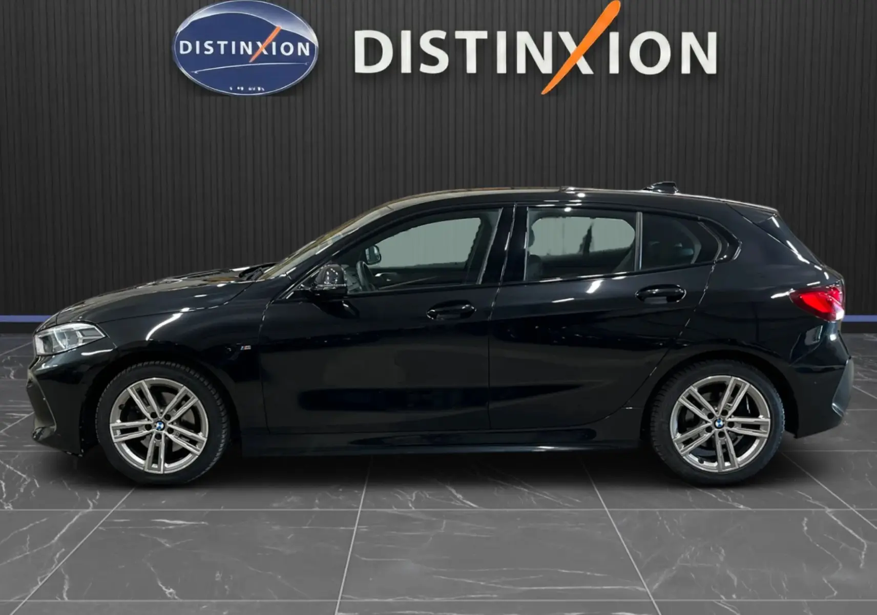 BMW Série 1 F40 118d M Sport noir métallisé vue de profil côté gauche avec jantes alliage et logo M Sport visible