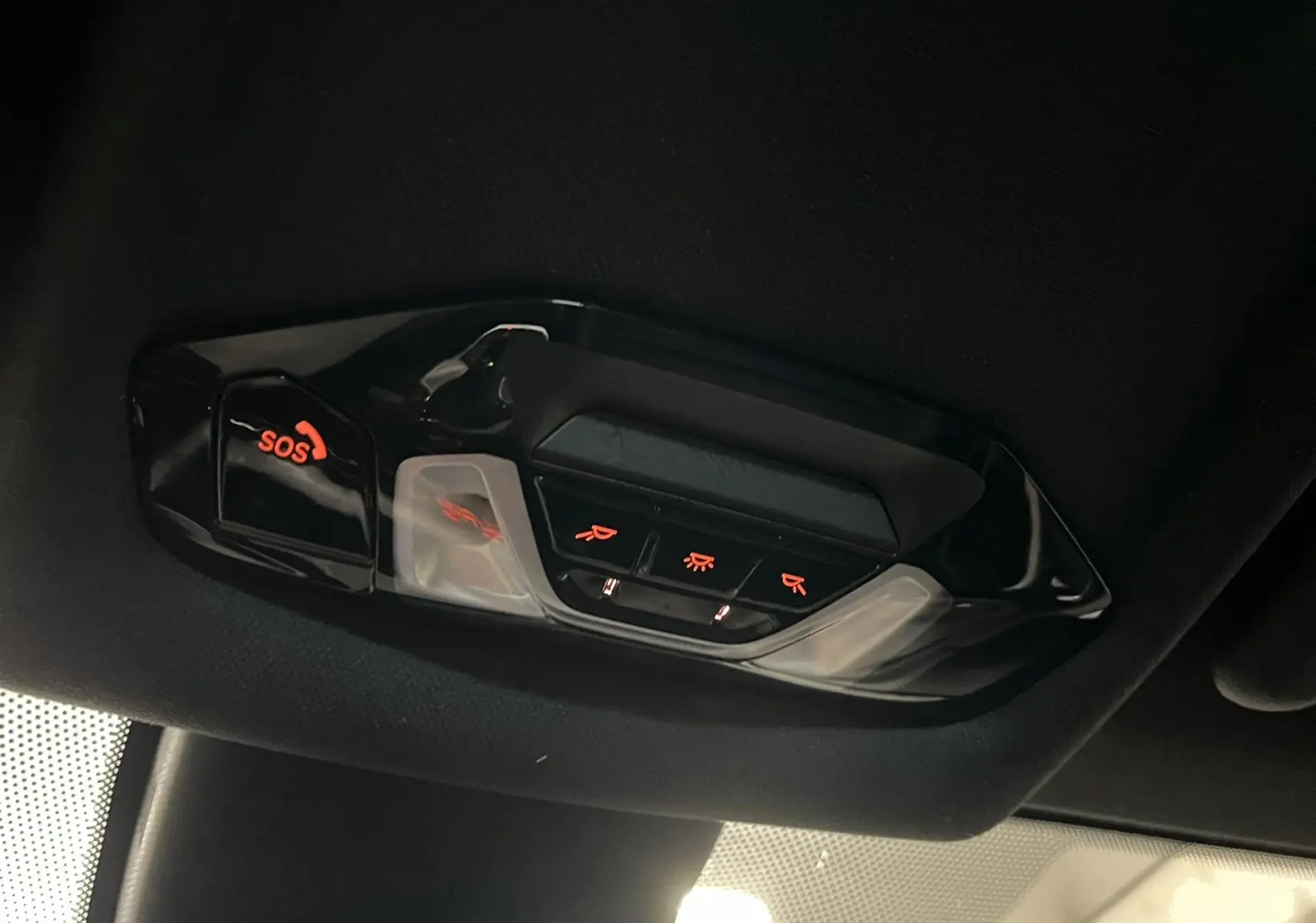 Vue intérieure du plafonnier avec boutons lumineux SOS et commandes d’éclairage dans une BMW Série 1 noire.