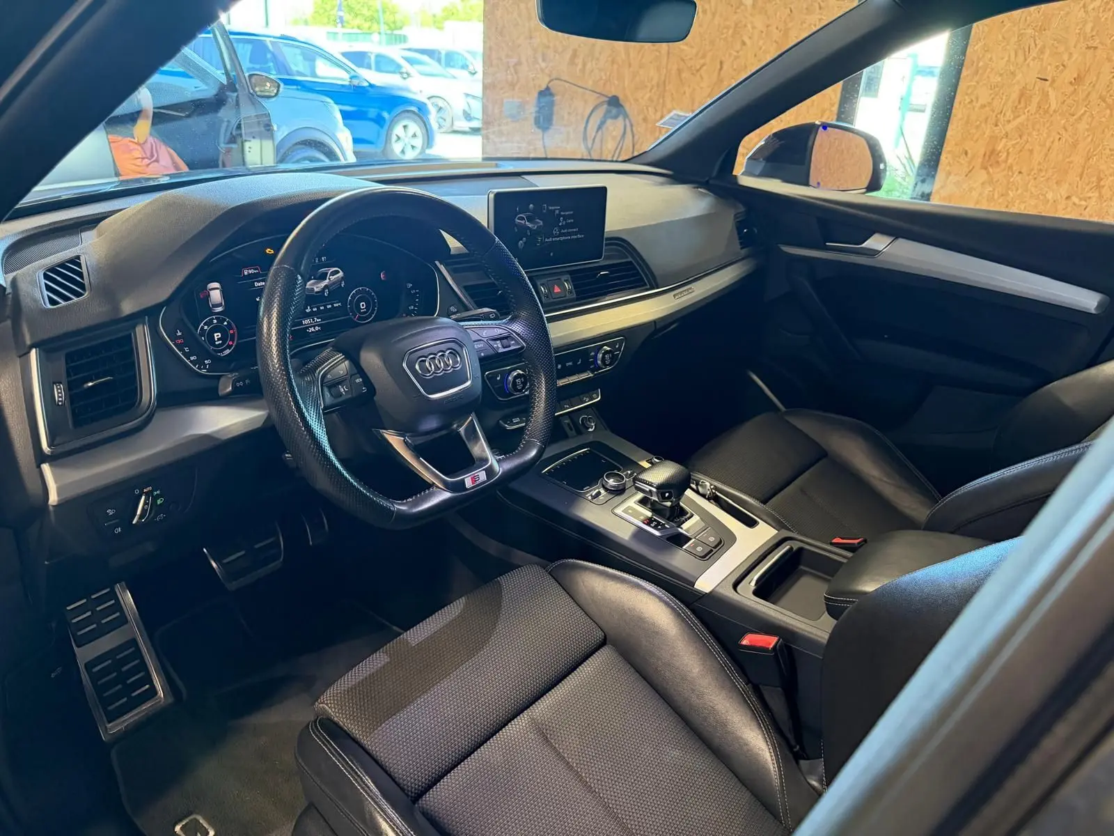 Intérieur noir de l'Audi Q5 Sportback 2019 vu côté conducteur, avec tableau de bord digital et console centrale moderne.