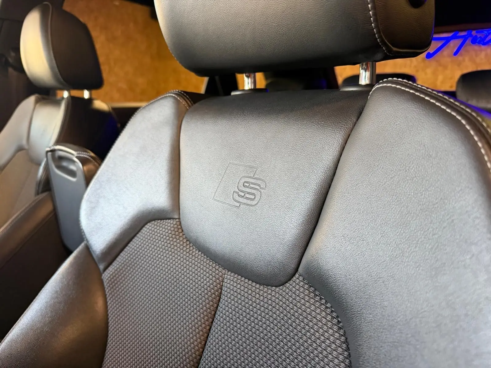 Gros plan sur le siège avant en cuir noir avec logo S embossé, intérieur de l'Audi Q5 Sportback gris 2019.