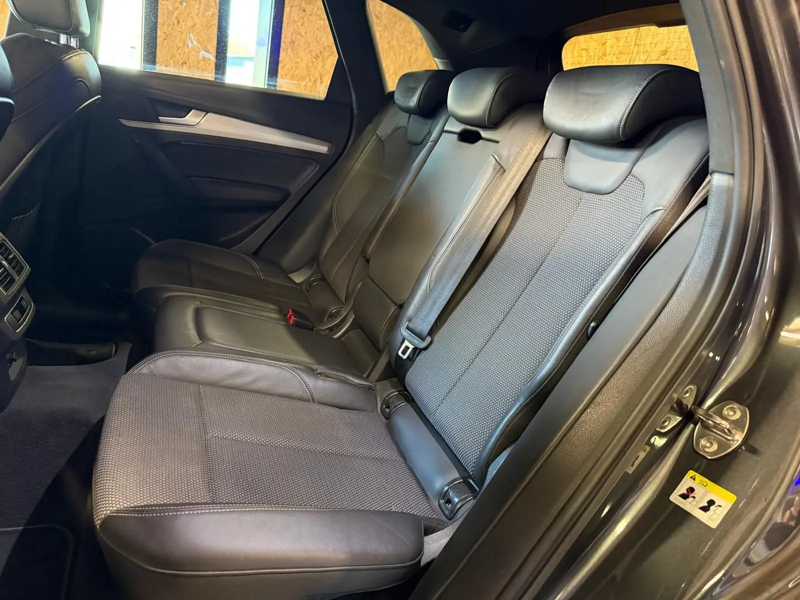 Vue intérieure côté droit des sièges arrière en cuir noir de l'Audi Q5 Sportback 2019 avec ceinture de sécurité visible.