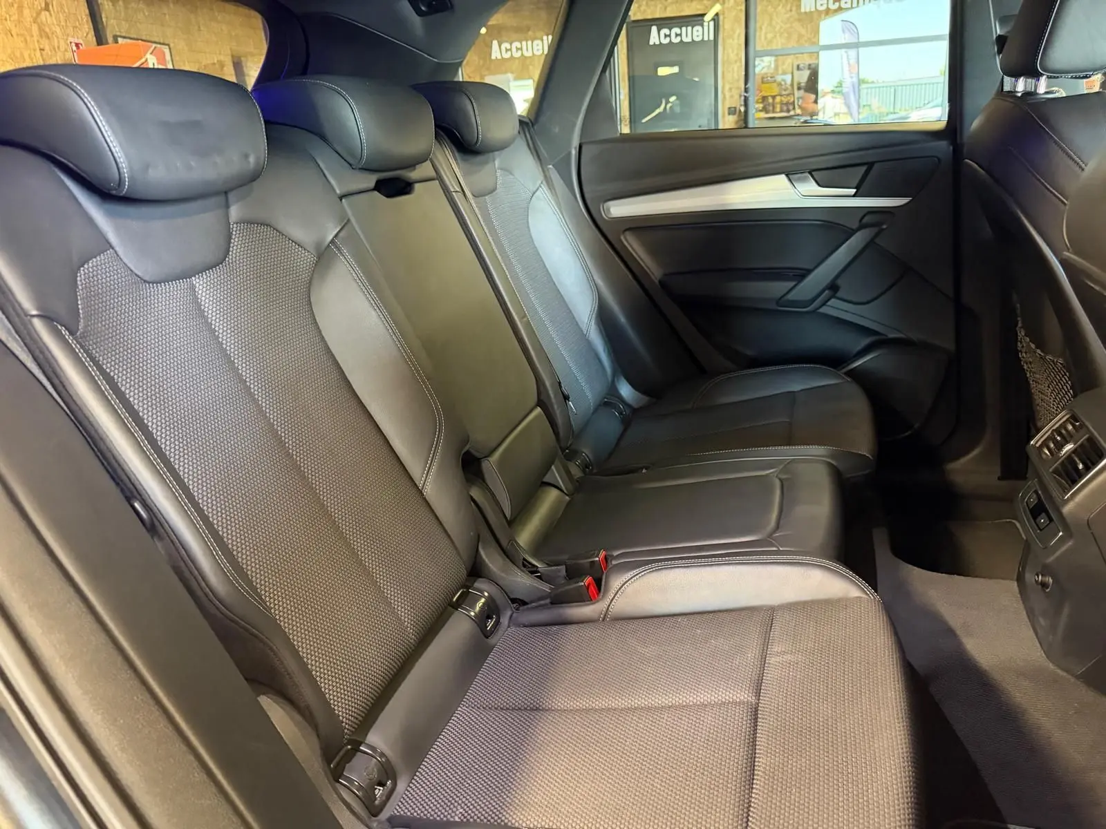 Vue intérieure côté droit des sièges arrière en cuir noir de l'Audi Q5 Sportback 2019, avec appuie-têtes et porte arrière visible.
