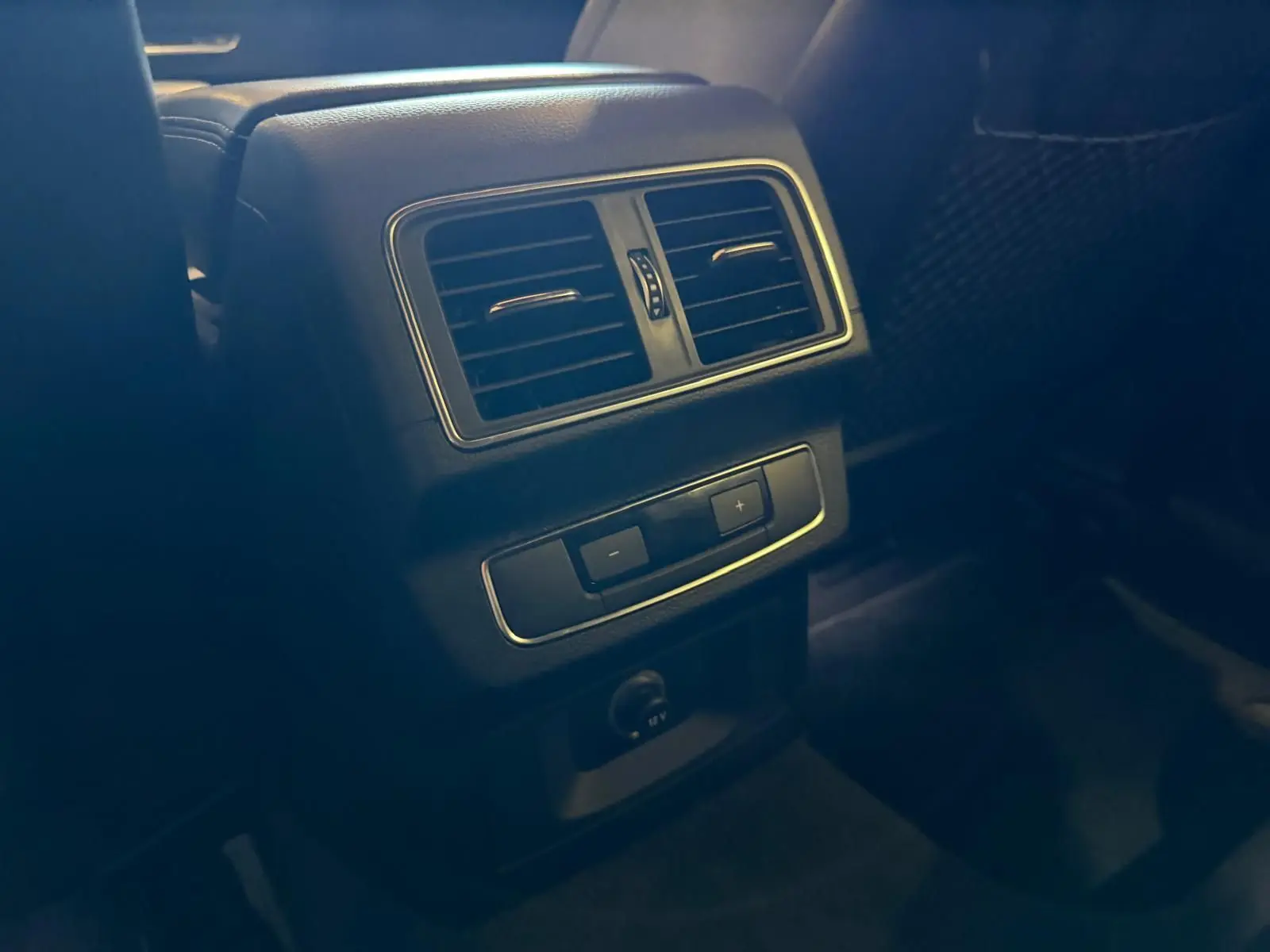 Détail de la console arrière avec bouches d’aération et commandes de climatisation dans l’Audi Q5 Sportback gris.