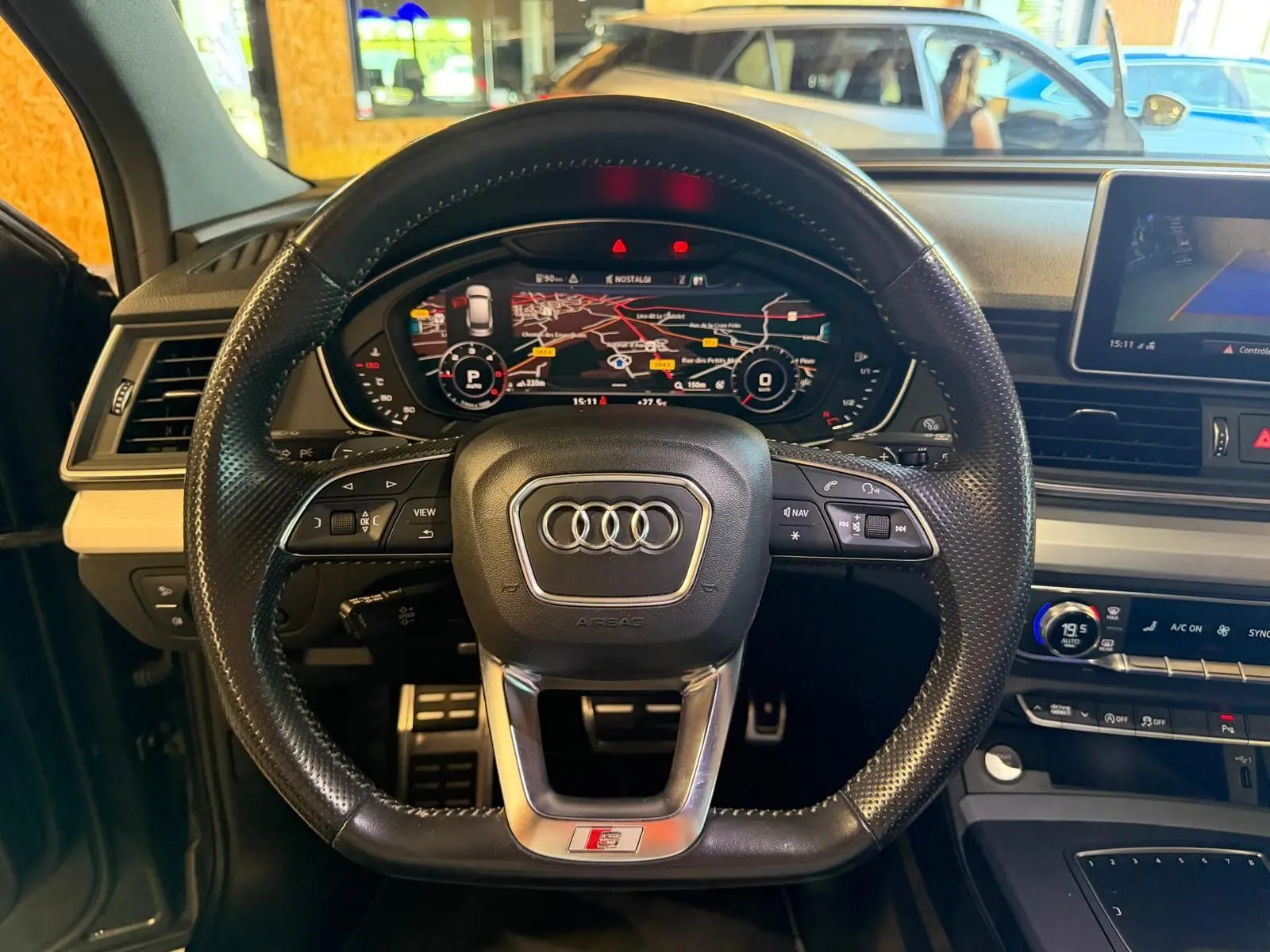 Vue intérieure centrée sur le volant S-Line noir perforé et le tableau de bord numérique de l'Audi Q5 Sportback 2019.