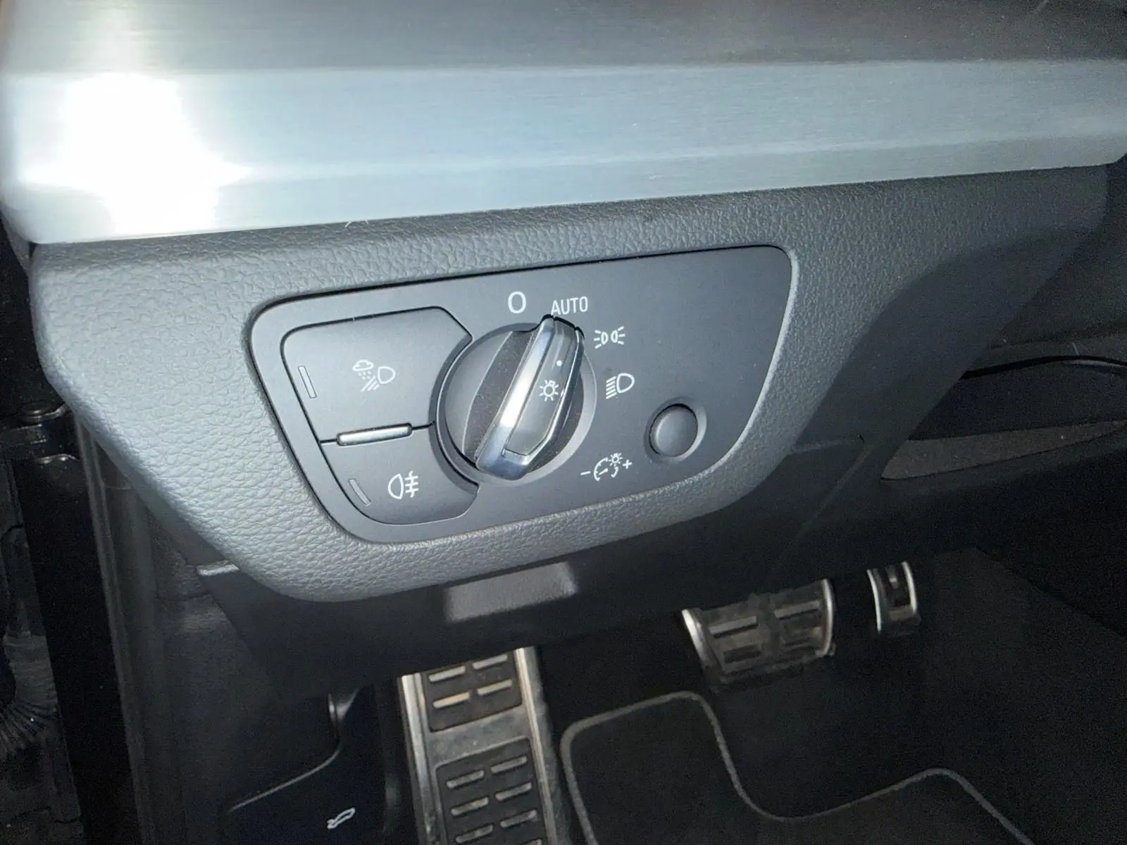 Gros plan sur le sélecteur d’éclairage et les pédales en aluminium de l’Audi Q5 Sportback gris, intérieur côté conducteur.