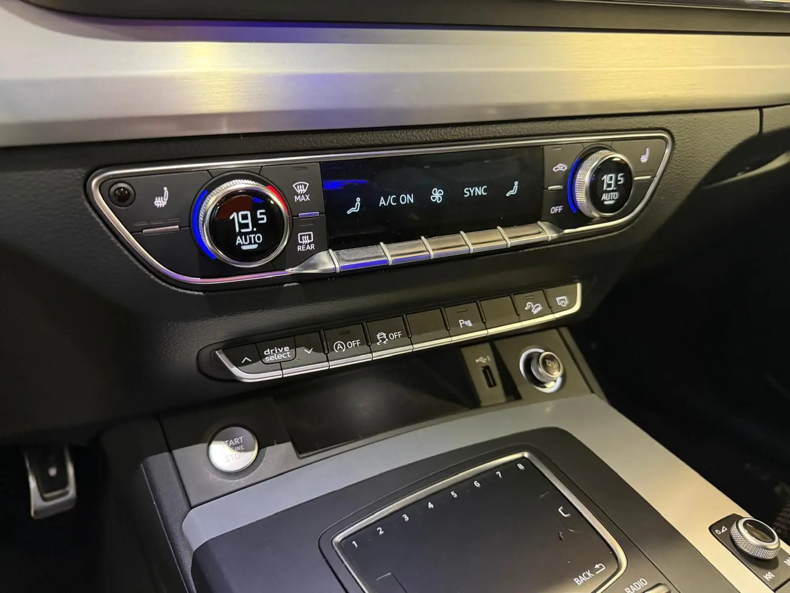 Vue rapprochée de la console centrale de l’Audi Q5 Sportback 2019, avec commandes climatisation digitale et boutons multifonctions.