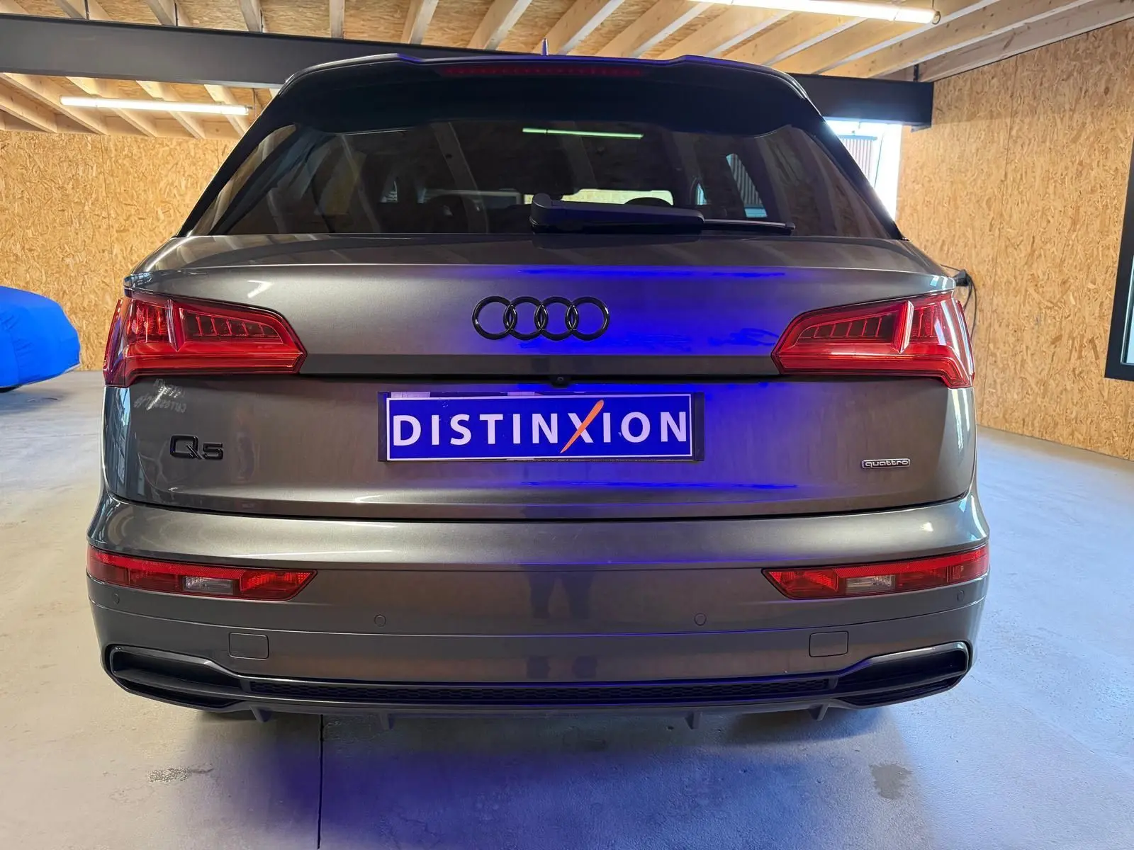Vue arrière d’un Audi Q5 Sportback gris 2019 avec logo Quattro et feux arrière LED distinctifs.