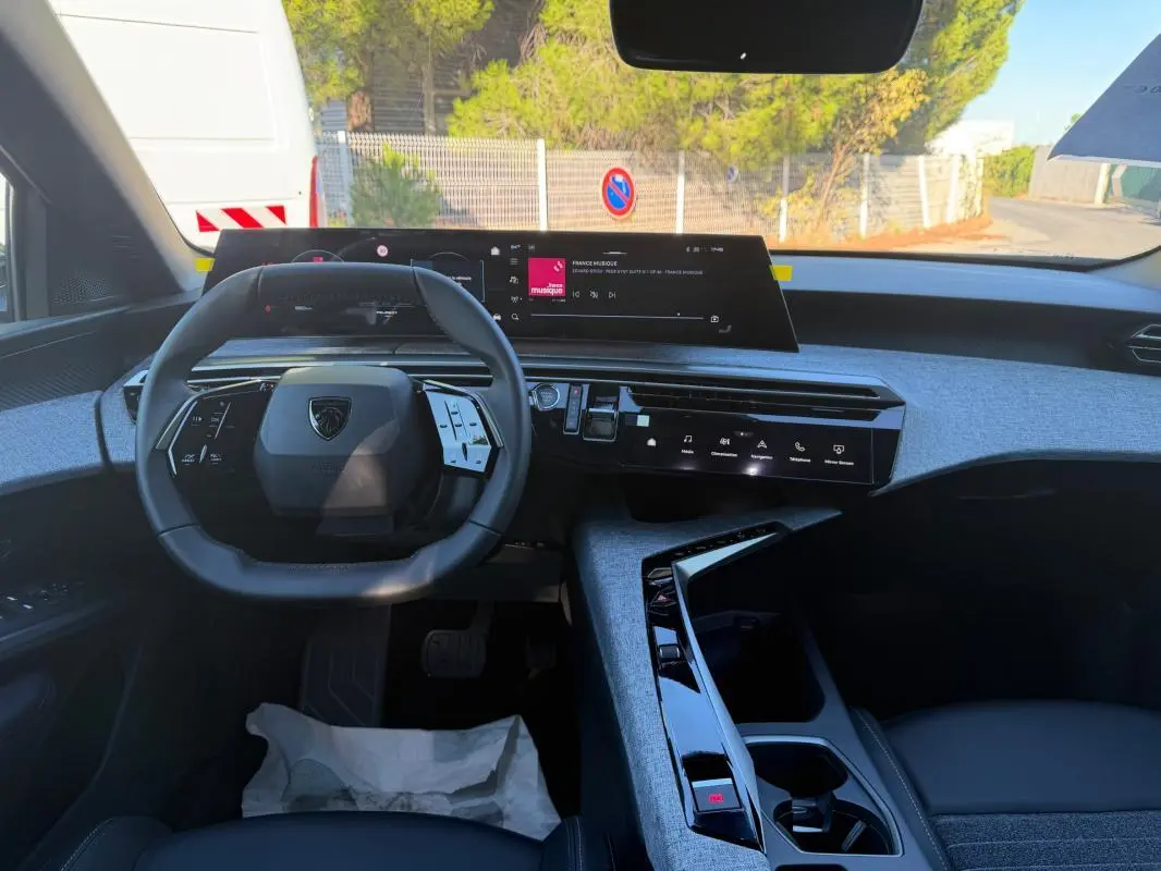 Vue intérieure du tableau de bord et volant du Peugeot 3008 Hybrid 145 Allure 2025, avec écran tactile et finitions grises.