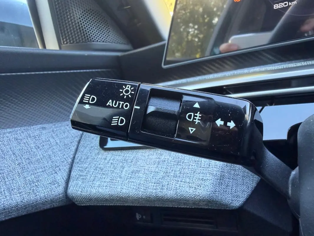 Gros plan sur la commande des feux et clignotants du Peugeot 3008 Hybrid 145 e-DCS6 Allure 2025, intérieur gris.