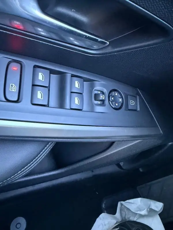 Vue rapprochée des commandes de lève-vitres et rétroviseurs côté conducteur du Peugeot 3008 Hybrid 145 e-DCS6 Allure bleu 2025.