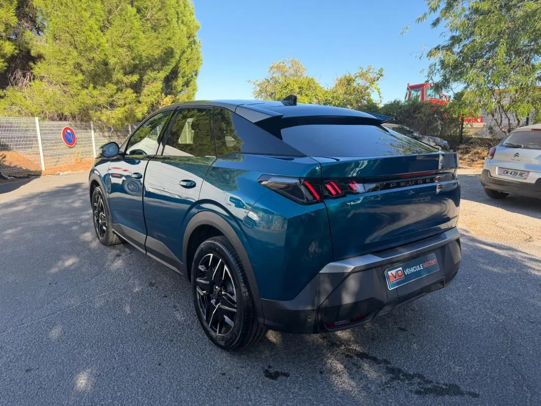 Vue 3/4 arrière droite du Peugeot 3008 Hybrid 145 e-DCS6 Allure bleu 2025 avec feux arrière distinctifs en forme de griffes.