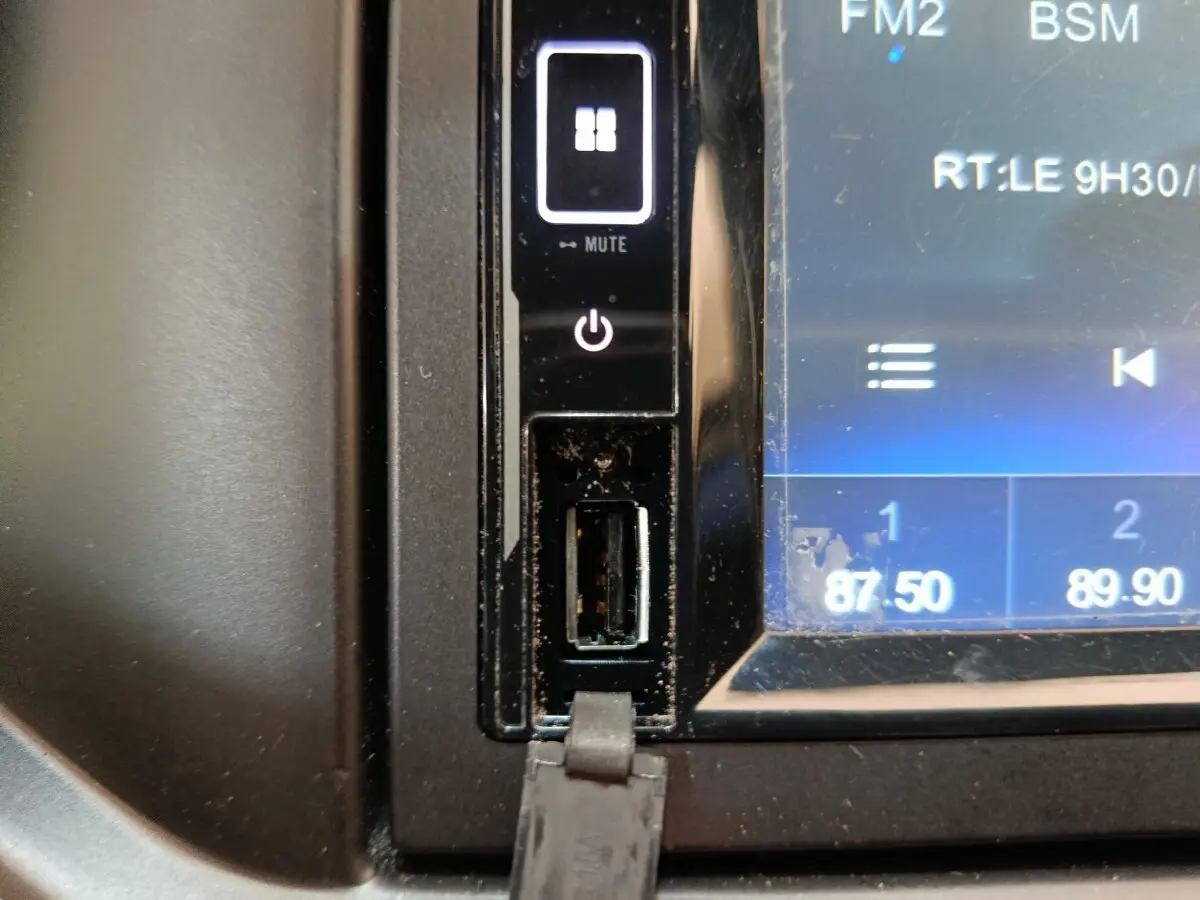 Gros plan sur la prise USB et les commandes tactiles du système multimédia de l'AIXAM Ambition blanc, version 2023.