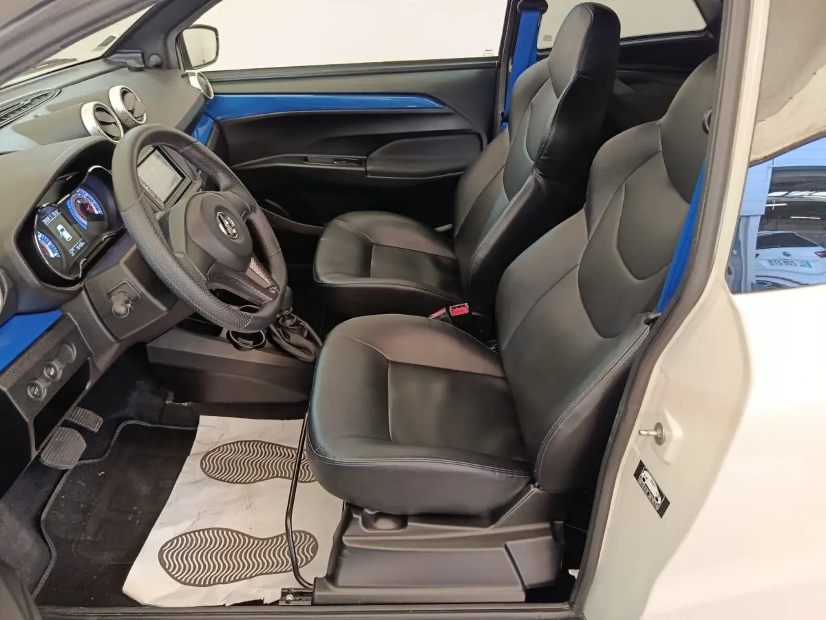 Vue intérieure côté conducteur de l'AIXAM Ambition 0.5 City Coupe GTI 2023, sièges noirs et tableau de bord bleu.