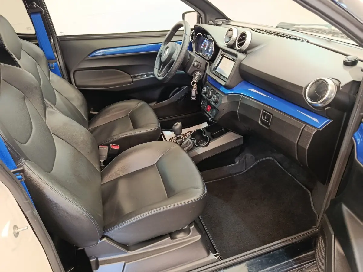 Vue intérieure côté conducteur de l'AIXAM Ambition 0.5 City Coupe GTI 2023, avec tableau de bord bleu et sièges noirs.