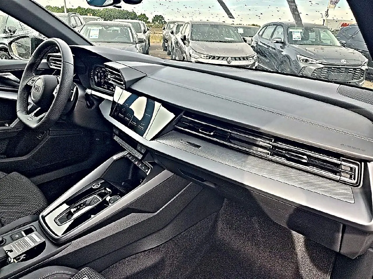 Vue intérieure côté conducteur de l’Audi A3 Sportback 2026 avec tableau de bord moderne et volant cuir noir.