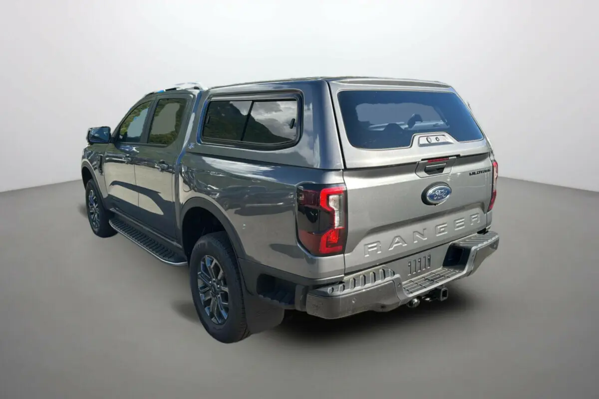 Ford Ranger gris carbone en 3/4 arrière droit avec hardtop vitré et jantes alu 18 pouces visibles.