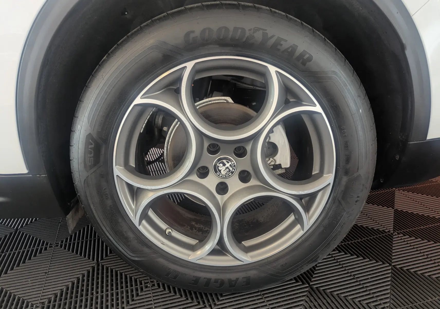 Gros plan sur la roue arrière droite blanche d'un Alfa Romeo Stelvio 2023 avec jante biton et pneu SUV.