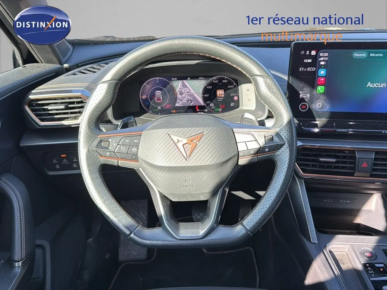 Vue intérieure centrée sur le volant en cuir noir perforé du CUPRA Formentor 1.4 E-HYBRID 2023 avec tableau de bord numérique.