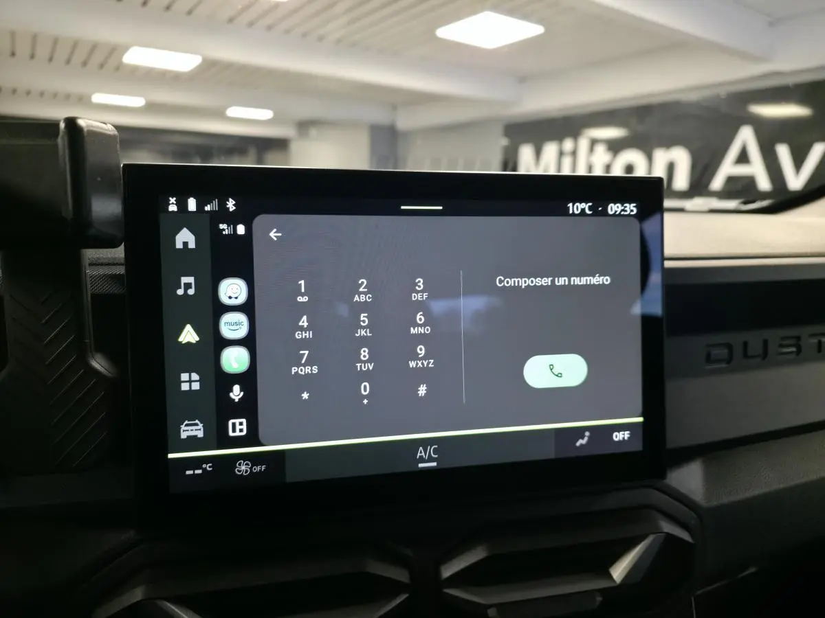 Écran tactile central du tableau de bord du Dacia Duster 2025, affichant le clavier pour composer un numéro.
