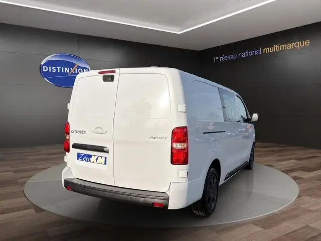 Vue 3/4 arrière droite d'un Citroën Jumpy cabine approfondie blanc, portes arrière battantes et jantes alu noires.