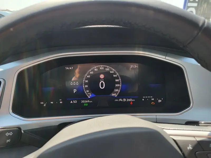 Vue intérieure du tableau de bord numérique du Volkswagen T-Roc 2025, affichage clair avec fond noir et détails blancs et bleus.