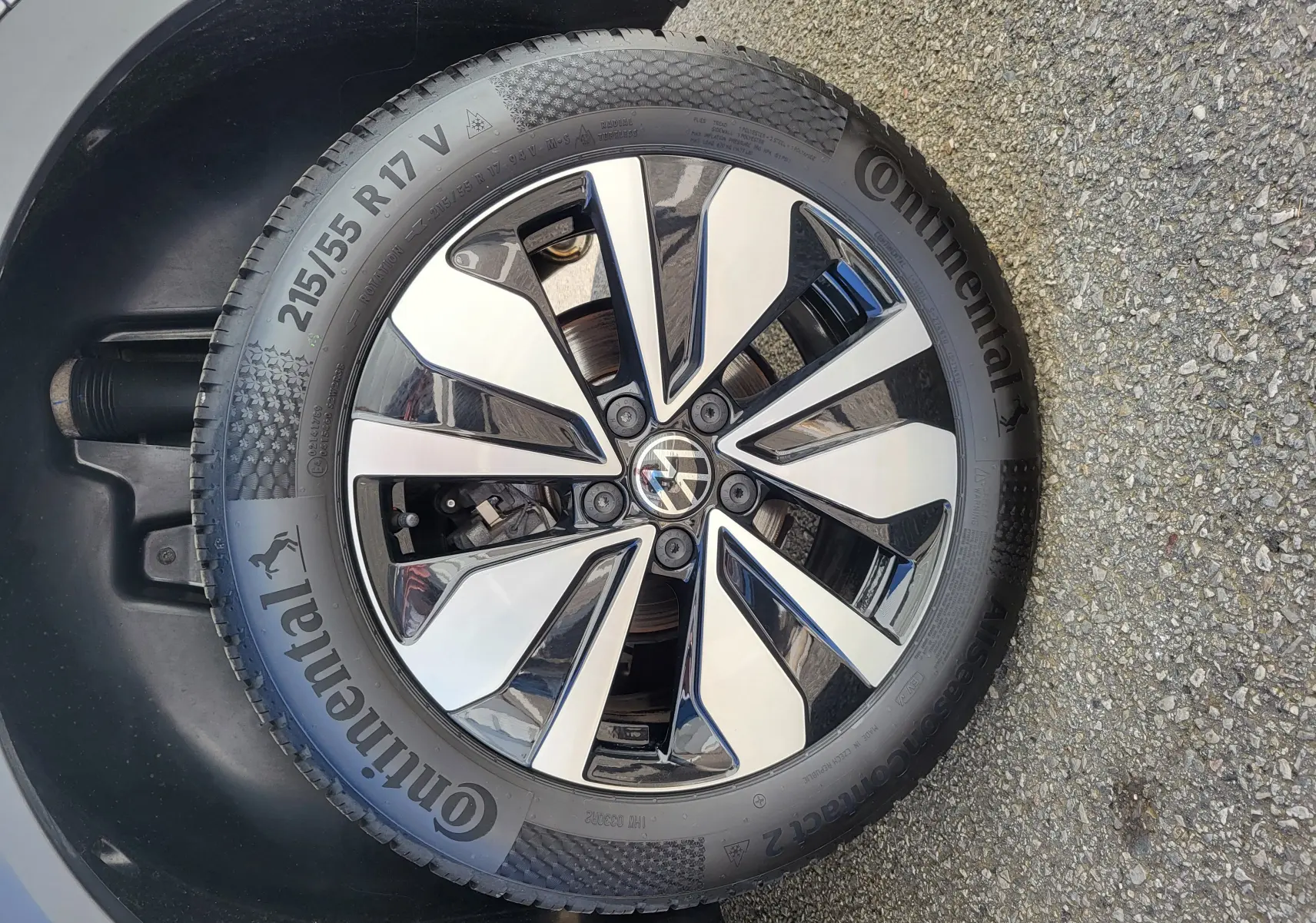 Gros plan sur la roue avant droite du Volkswagen T-Roc gris Indium, jante alliage bicolore et pneu Continental 215/55 R17.