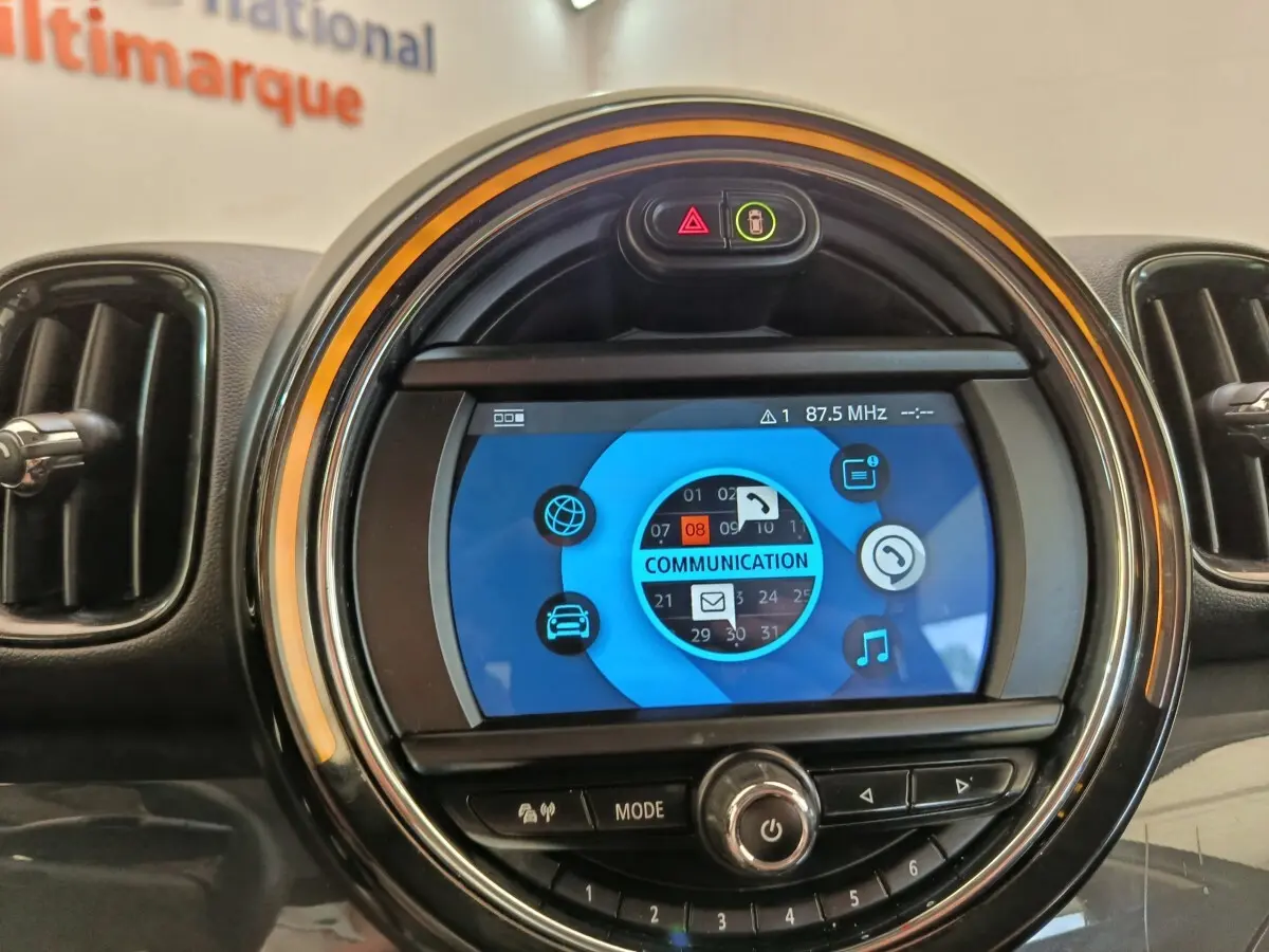 Détail du tableau de bord MINI Countryman 2019 noir, écran central rond avec interface multimédia bleue.