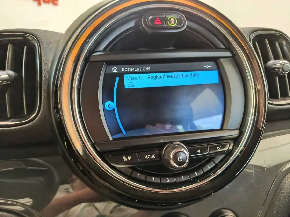 Gros plan sur l'écran central rond du tableau de bord noir du MINI Countryman 2019 avec affichage de notifications.
