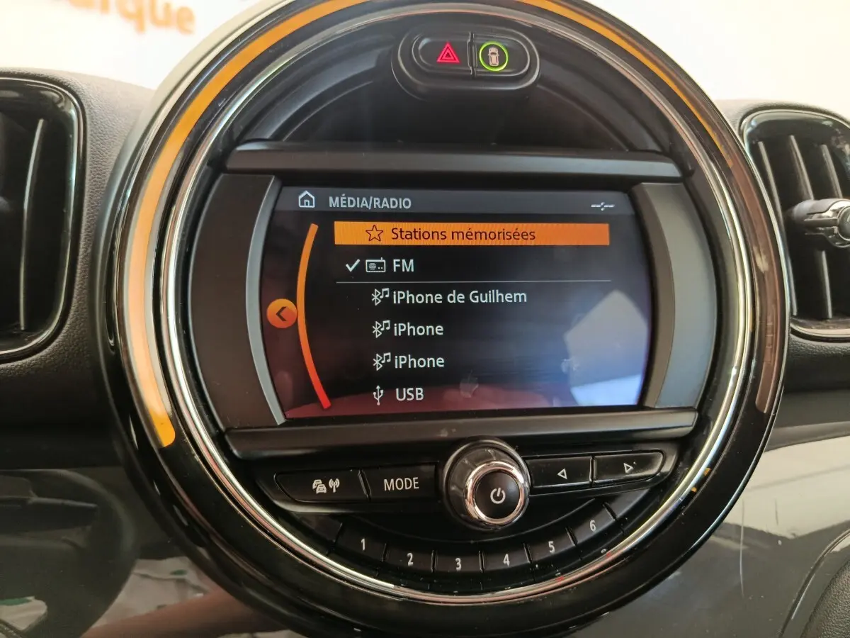 Écran central rond du tableau de bord MINI Countryman 2019 affichant les options média et radio, vue de face.