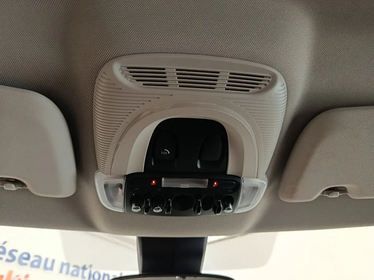 Vue intérieure en gros plan du plafonnier beige avec commandes et éclairage dans une MINI Countryman noire de 2019.