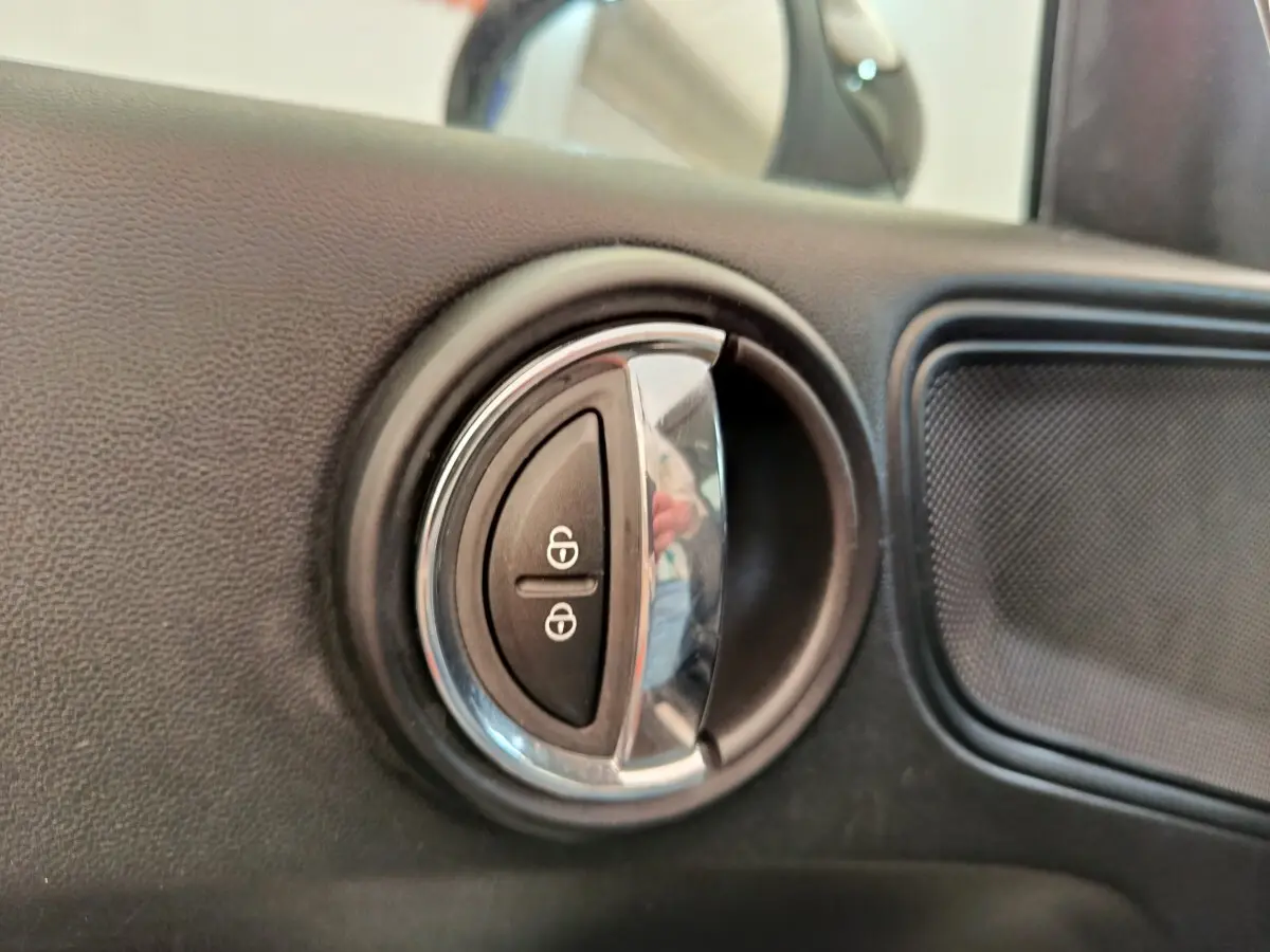 Détail de la commande de verrouillage des portes dans l’habitacle noir d’une MINI Countryman Cooper 2019.