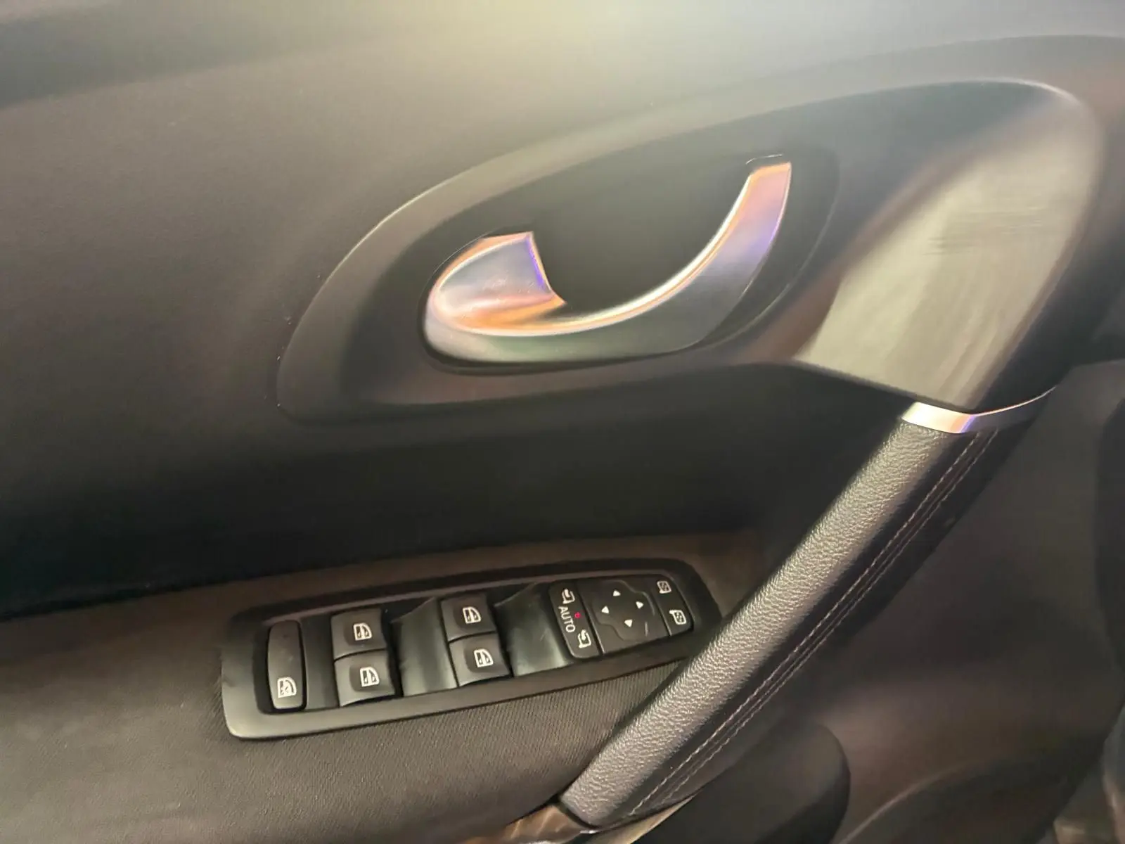 Poignée de porte intérieure côté gauche avec commandes des vitres sur Renault Kadjar gris, finition tissu noir.