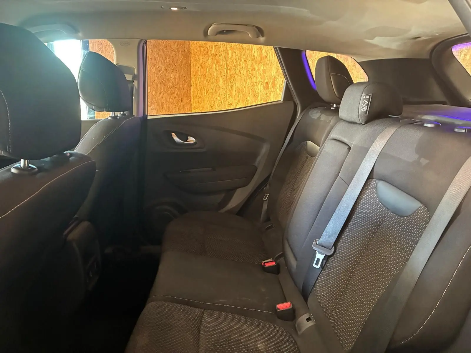 Vue intérieure côté droit des sièges arrière en tissu noir du Renault Kadjar gris, version 2019, avec ceintures de sécurité visibles.