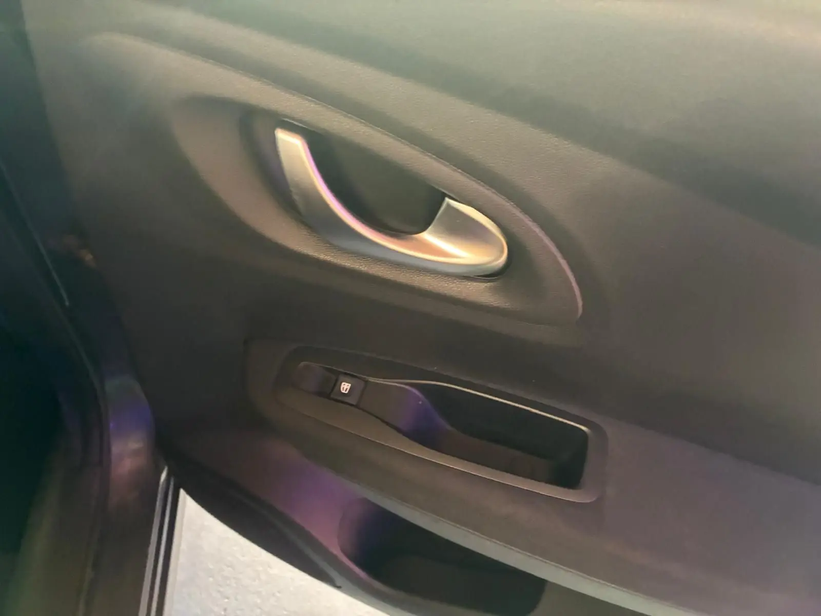 Poignée intérieure et commande de lève-vitre côté gauche du Renault Kadjar gris, finition tissu noir.