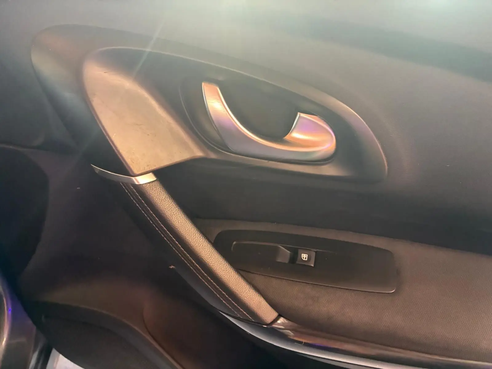 Poignée de porte intérieure côté gauche du Renault Kadjar 2019, finition tissu noir avec bouton de verrouillage.
