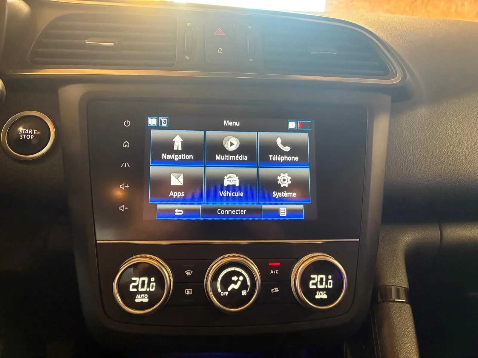 Vue rapprochée de la console centrale du Renault Kadjar 2019, écran tactile et commandes de climatisation visibles.