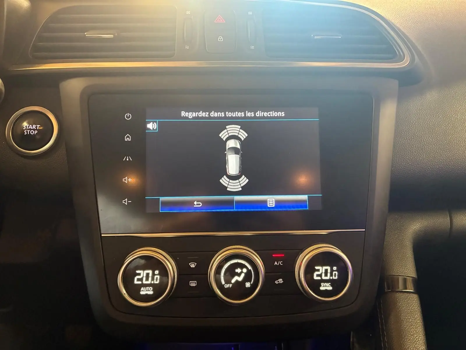 Vue rapprochée de la console centrale du Renault Kadjar gris 2019, avec écran tactile et commandes climatisation digitales.