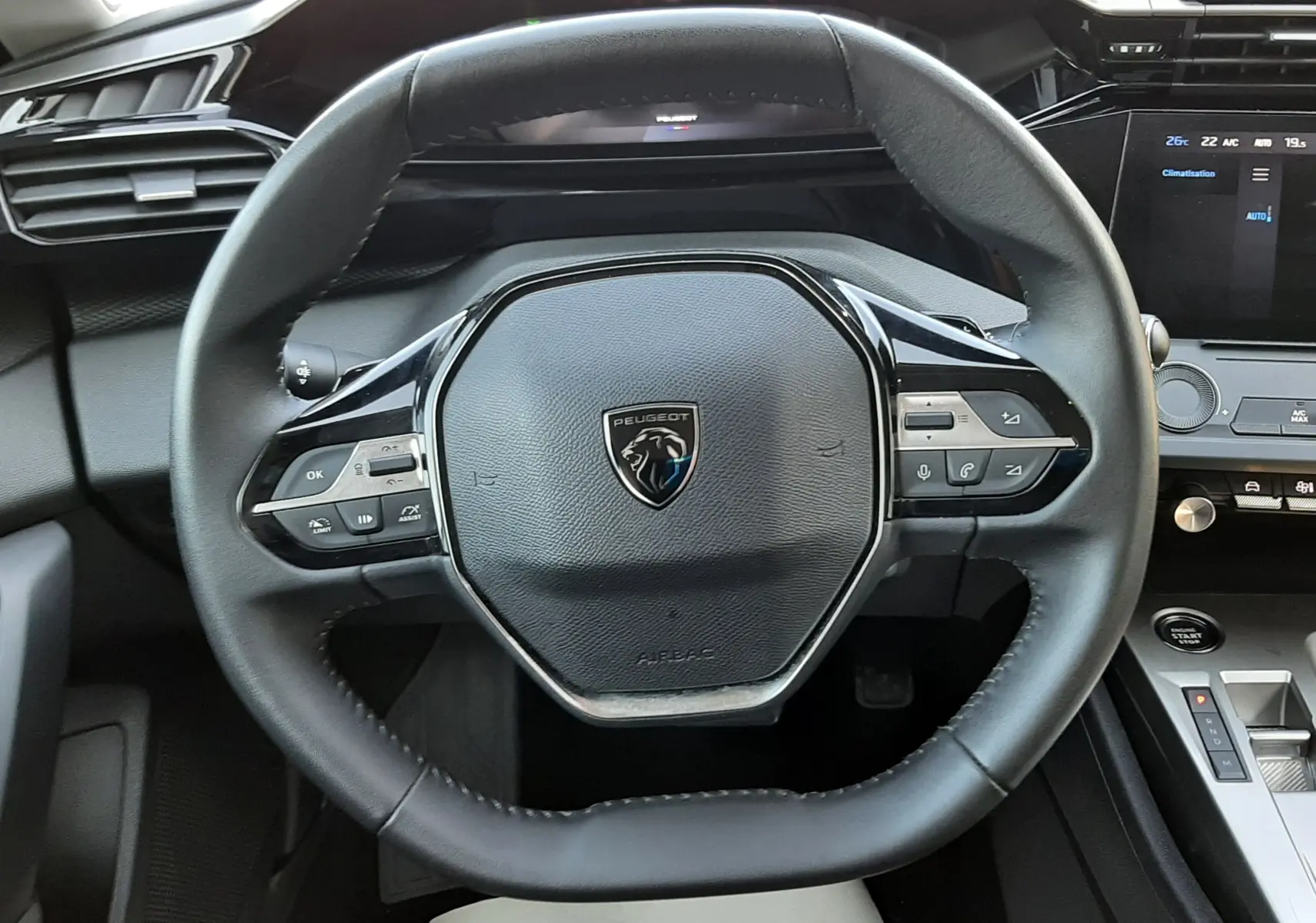 Vue rapprochée du volant cuir noir de la Peugeot 308 III Hybrid 145ch Style, avec commandes intégrées et tableau de bord numérique.