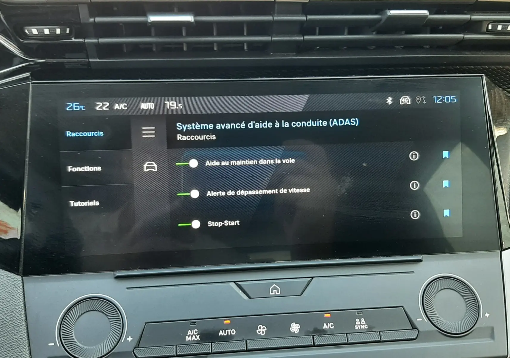 Vue rapprochée de l’écran tactile central du tableau de bord du Peugeot 308 gris, affichant les aides à la conduite.