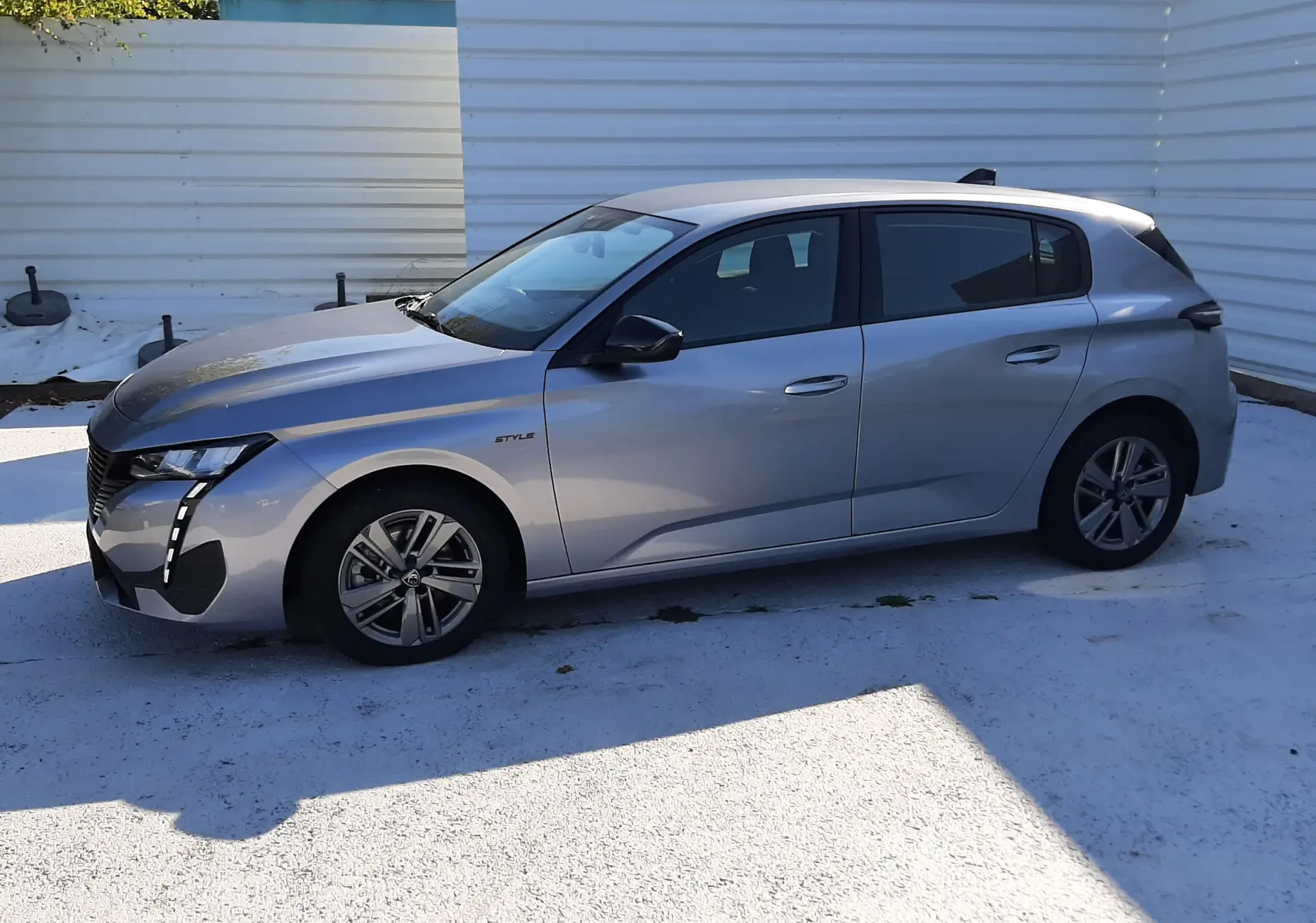 Peugeot 308 III Hybrid gris Artense vue de profil côté gauche, avec jantes alliage et vitres teintées.